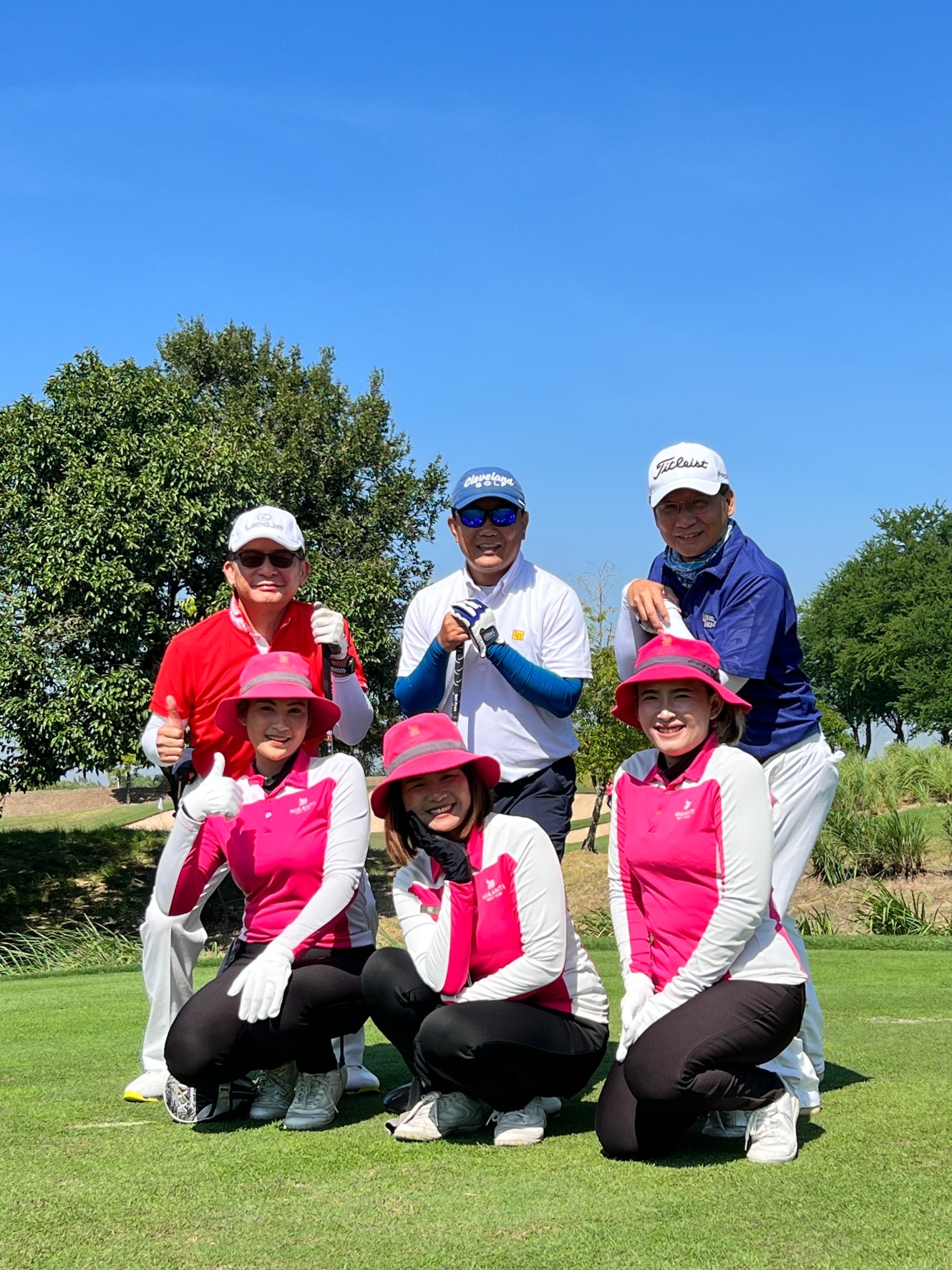 Golfers walking down a fairway at sunset in Thailand